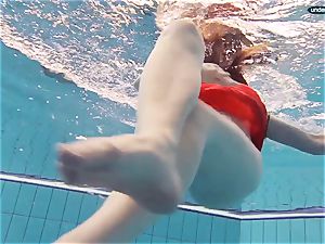 red clothed teen swimming with her eyes opened